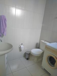 阿雷格里港Próximo ao Consulado - Quarto Inteiro的浴室配有卫生间、盥洗盆和洗衣机。