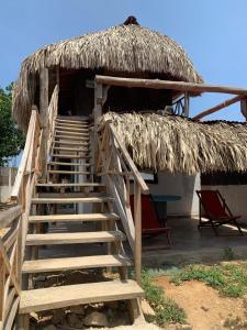 RincónSauka Loft的通往带草屋顶小屋的楼梯