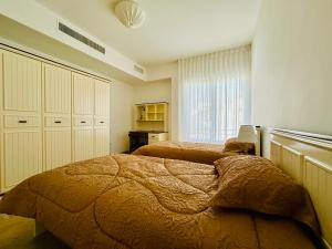 安曼Abdoun Place的一间卧室设有两张床和窗户。