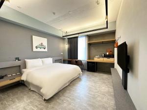 莺歌区私客创旅 的卧室配有一张白色大床和一张书桌