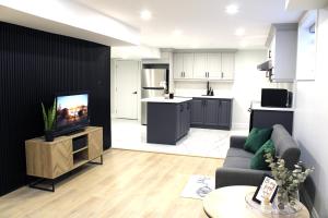 NewcastleUrban Haven: 2BR/2BA+Office, Kitchen, Dining的带沙发和电视的客厅