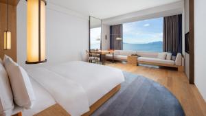 大理大理洱海天域英迪格酒店的一间带白色大床的卧室和一间客厅