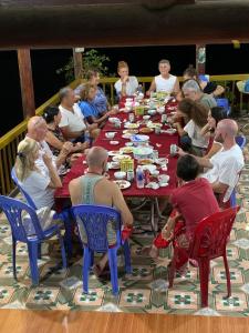 北市Pac Ngoi Village's homestay (Ba Be Lake)的一群人坐在一张长桌旁