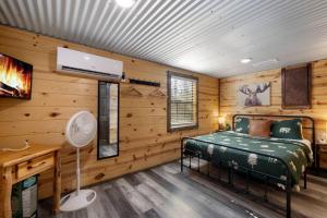 布罗肯鲍Cozy Cabin 3br, Hot tub, playset, Near Everything!的卧室配有一张床铺,位于带木墙的房间内