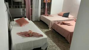 麦德林Casa Nogal 76的一间设有三张床的客房,配有粉红色枕头