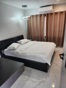 万象PND apartment 코너룸 한국식 콘도的卧室内的一张带白色床单和枕头的床