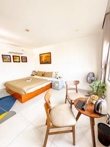 岘港Hồng Châu Hotel的卧室配有一张床和一张桌子及椅子