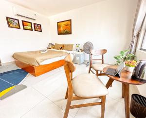 岘港Hồng Châu Hotel的一间卧室配有一张床、一张桌子和一把椅子