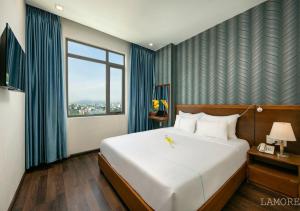 岘港L'emore Hotel Da Nang的卧室设有一张白色大床和一扇窗户。