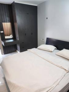 万象PND apartment 코너룸 한국식 콘도的一间卧室配有一张白色大床和黑色床头板