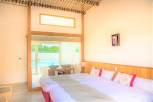 Fukaiコーラルテラス石垣島的一间卧室设有一张床和一个大窗户
