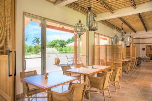Fukaiコーラルテラス石垣島的一间带桌椅的用餐室和一个庭院