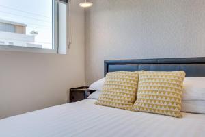 悉尼Cosy 1-Bedroom Apartment Close to the City的一张带黄色和白色床单的床和窗户