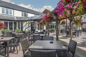 哈波罗集市The Three Swans Hotel, Market Harborough, Leicestershire的户外庭院设有桌椅和鲜花