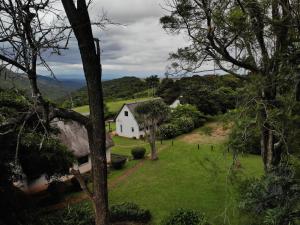 SitekiMabuda Guest Farm的一座白色的山丘房子,有绿色的庭院