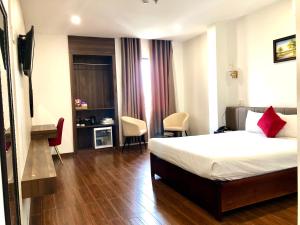 波来古市Le Centre Pleiku Hotel的酒店客房带一张床、一张桌子和椅子