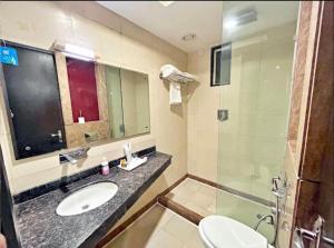 孟买Hotel BENTLY Terminal-2的浴室配有卫生间、盥洗盆和淋浴。