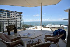 雷德克利夫Redvue Holiday Apartments的一个带桌椅的海景阳台