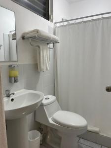 危地马拉Inari Hostal的白色的浴室设有卫生间和水槽。