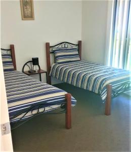 穆尔瓦拉DBJ假日公寓的两张睡床彼此相邻,位于一个房间里