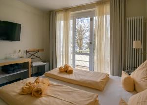 乌尔丁根-米赫尔霍芬Hotel & Restaurant Mainaublick的两张位于酒店客房的床,配有毛巾