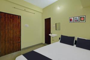 ChittoorSPOT ON SV Lakshmi Residency的一间卧室设有一张大床和一扇木门