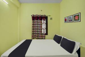 ChittoorSPOT ON SV Lakshmi Residency的一间卧室设有一张床和一个窗口