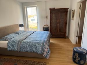 策勒Allerinsel - Appartement am Celler Yachthafen的一间卧室配有一张带蓝色毯子的床和窗户。