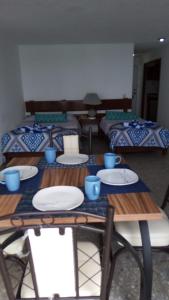 阿卡普尔科Hermosa Suite en Acapulco的一张桌子,上面有盘子,有两张床