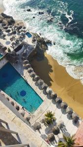 阿卡普尔科Hermosa Suite en Acapulco的享有毗邻大海的游泳池的顶部景致