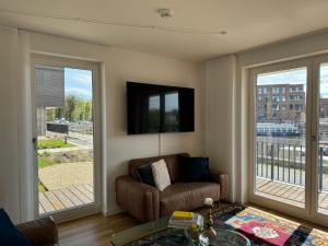 策勒Allerinsel - Appartement am Celler Yachthafen的带沙发和窗户的客厅