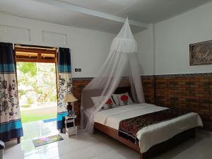 姆杜克Gosela Homestay的一间卧室配有一张带蚊帐的床