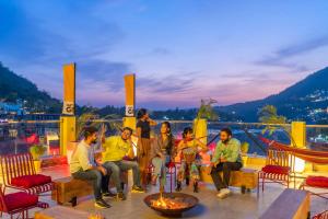 瑞诗凯诗The Hosteller Rishikesh, Ganges的一群人坐在甲板上的火堆旁