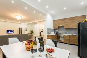第比利斯Premium 2 Bedroom Apartment lll的厨房以及带酒杯桌子的用餐室