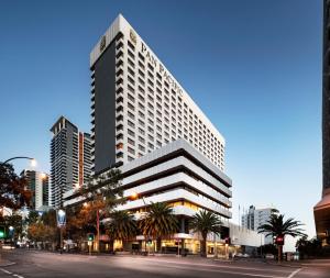 珀斯珀斯泛太平洋酒店的一座高大的建筑,在城市里种有棕榈树