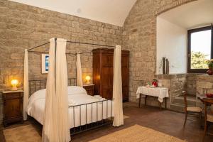蒙泰卡蒂尼瓦尔迪切奇纳Torre dei Belforti的一间卧室配有一张天蓬床和一张桌子