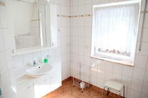Markische HeideFerienwohnung und Pension Jentsch的白色的浴室设有水槽和窗户。