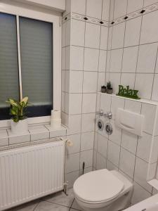 奥伯豪森Wohnung in Oberhausen: zentral & ruhig, eigener Eingang的白色的浴室设有卫生间和窗户。