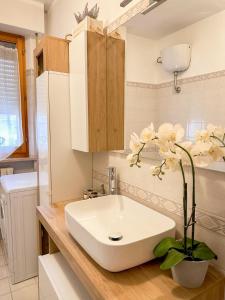 法尔科纳拉·玛里提马La casa di Lory的浴室设有白色水槽和花朵,位于柜台上