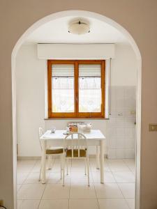 法尔科纳拉·玛里提马La casa di Lory的厨房配有桌子和两把椅子,设有窗户。