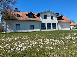 LärbroHangvar Skola Geografisalen的一座白色的大房子,花田