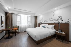 北京北京天安门逸扉酒店的酒店客房配有一张床、一张书桌和一张书桌。