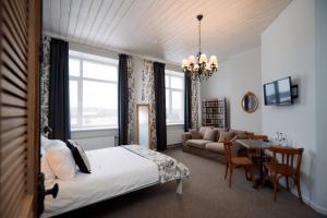 SileneSilene Resort & SPA Egles Villa的一间卧室设有一张床和一间客厅。