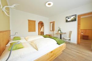 滨湖采尔吉蒂加尼乡村别墅酒店的一间卧室配有一张带白色床单和绿色枕头的大床。