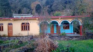 MunsyariComet Himalayan Paradise Homestay, Munsiyari的田间中的小房子