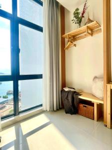 哥打京那巴鲁Cozy Ocean View APT in KK City Center的客房设有大窗户和长凳,享有美景。