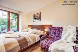 斯维诺乌伊希切Baltic Apartments - Hotelik Przy Promenadzie的一间卧室配有两张床和椅子