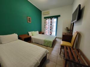 卡梅纳维洛拉PANTHEON HOLIDAY INN的酒店客房设有两张床和电视。