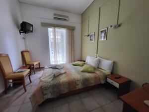 卡梅纳维洛拉PANTHEON HOLIDAY INN的一间卧室配有一张床、两把椅子和一个窗户