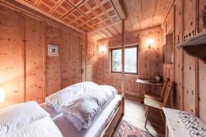 雷西亚Chalet am Reschensee的小木屋内一间卧室,配有两张床